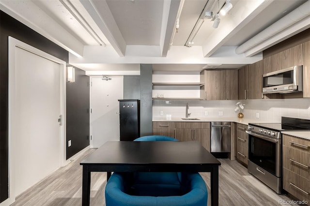 1495 Vrain St Unit 110, Denver, CO 80204 - kitchen featuring stainless steel appliances, light wood-style floors, open shelves, and tasteful backsplash