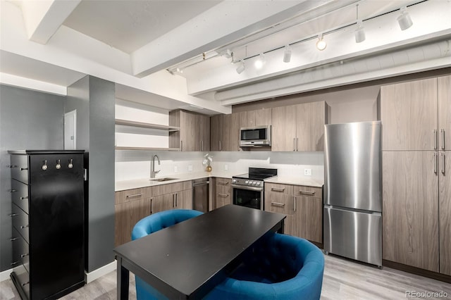 1495 Vrain St Unit 110, Denver, CO 80204 - kitchen with stainless steel appliances, rail lighting, open shelves, and light wood finished floors
