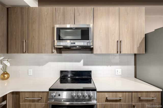 1495 Vrain St Unit 110, Denver, CO 80204 - kitchen with stainless steel appliances, modern cabinets, light countertops, tasteful backsplash, and brown cabinetry