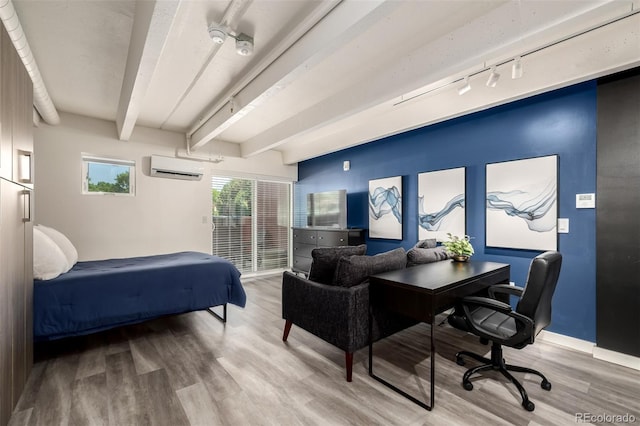 1495 Vrain St Unit 110, Denver, CO 80204 - bedroom featuring an AC wall unit, beam ceiling, wood finished floors, rail lighting, and a desk