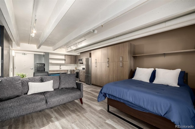 1495 Vrain St Unit 110, Denver, CO 80204 - bedroom with freestanding refrigerator, light wood-style floors, beamed ceiling, and rail lighting