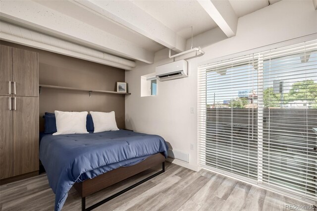 1495 Vrain St Unit 110, Denver, CO 80204 - bedroom with a wall mounted AC, beam ceiling, wood finished floors, and access to outside