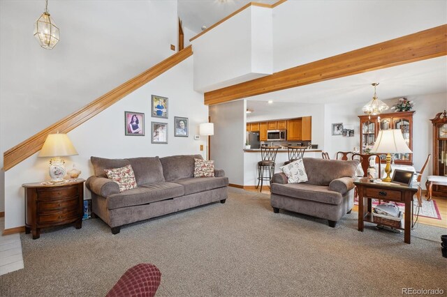 living room with light carpet, a notable chandelier, a towering ceiling, and baseboards