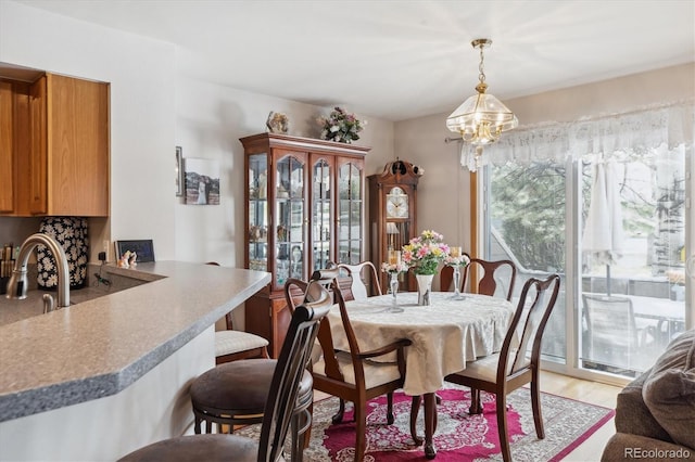 dining area with light wood finished floors and a notable chandelier