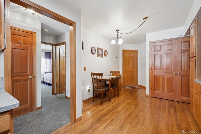 interior space featuring light wood finished floors, baseboards, a chandelier, and visible vents