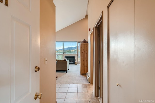 corridor with light colored carpet, lofted ceiling, and a baseboard radiator