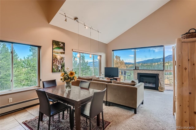 dining room featuring light tile patterned floors, a baseboard radiator, high vaulted ceiling, and a healthy amount of sunlight