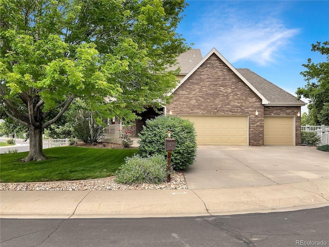 642 52nd Ave, Greeley, CO 80634 - view of front of house featuring an attached garage, driveway, brick siding, and a shingled roof