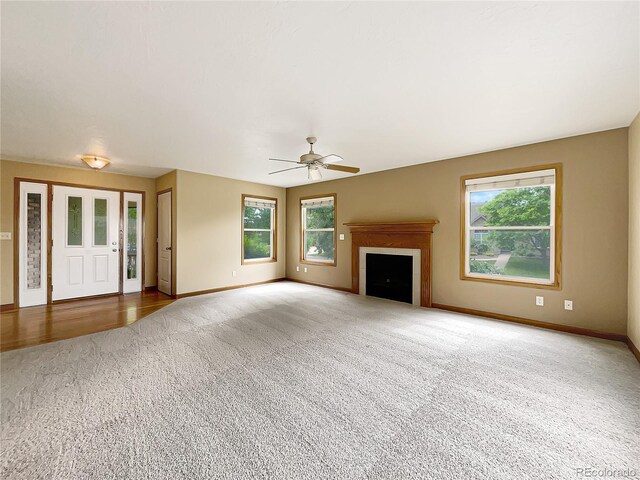 642 52nd Ave, Greeley, CO 80634 - unfurnished living room featuring carpet floors, healthy amount of natural light, ceiling fan, and a fireplace