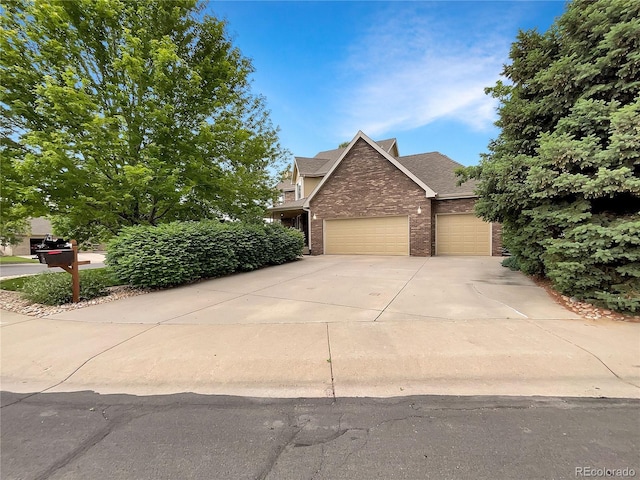 642 52nd Ave, Greeley, CO 80634 - view of front of home featuring brick siding, driveway, an attached garage, and a shingled roof