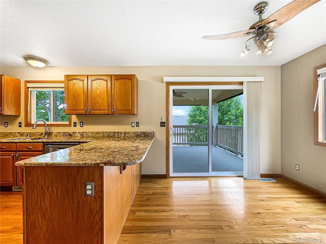642 52nd Ave, Greeley, CO 80634 - kitchen with a peninsula, brown cabinets, light wood-style flooring, and a ceiling fan