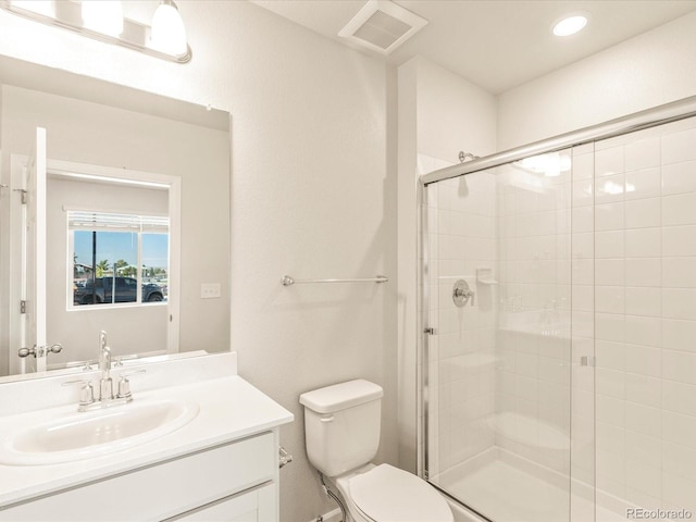 bathroom featuring vanity, an enclosed shower, and toilet