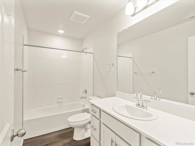 full bathroom with hardwood / wood-style flooring, shower / washtub combination, toilet, and vanity