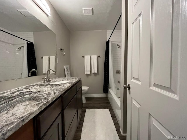 full bathroom with shower / tub combo, vanity, hardwood / wood-style flooring, and toilet