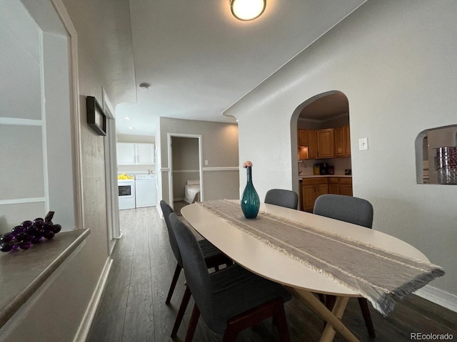 dining space with washer and dryer and dark wood-type flooring