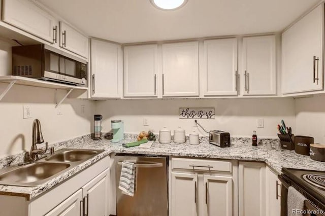 kitchen with white cabinetry, sink, stainless steel appliances, and light stone counters