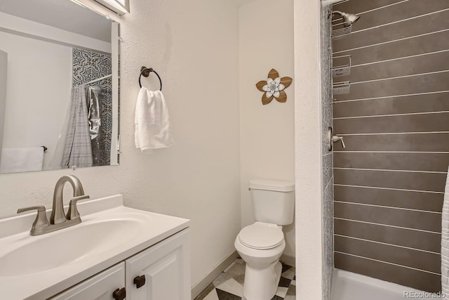 bathroom featuring tiled shower, tile patterned floors, vanity, and toilet