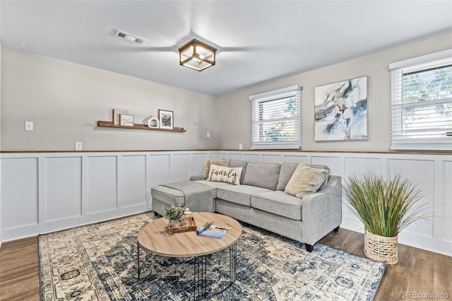 4512 S Yank St, Morrison, CO 80465 - living room with healthy amount of natural light, wood finished floors, a wainscoted wall, and a decorative wall