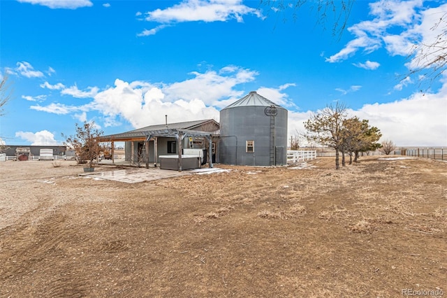 rear view of house with a patio area, a hot tub, and fence