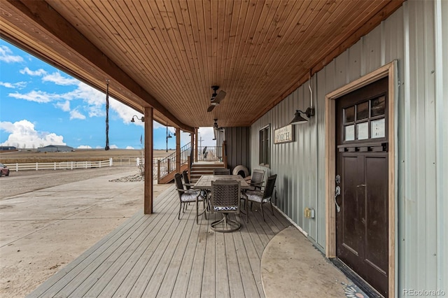 wooden terrace with outdoor dining area and fence