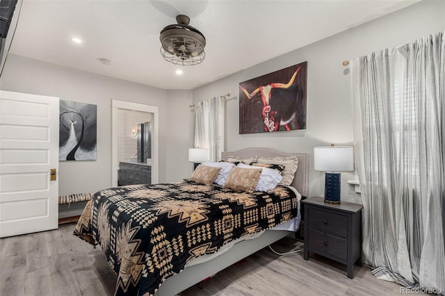 bedroom featuring recessed lighting, wood finished floors, and connected bathroom