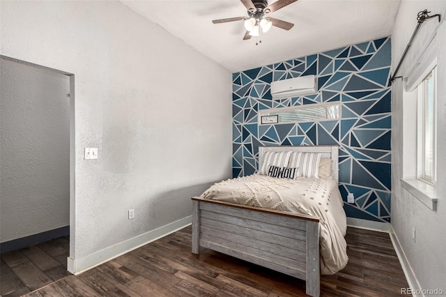 living area with an accent wall, a ceiling fan, an AC wall unit, wood finished floors, and baseboards