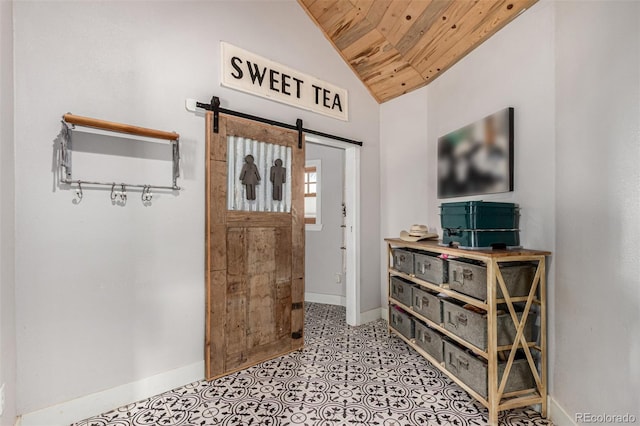 foyer entrance with lofted ceiling, wooden ceiling, a barn door, and baseboards