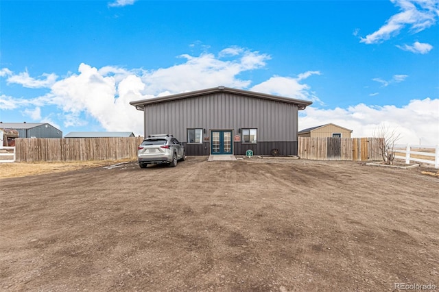 view of outbuilding with fence and french doors