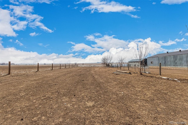 view of yard featuring a rural view and fence