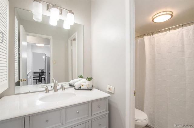 full bath featuring vanity, a shower with shower curtain, and toilet