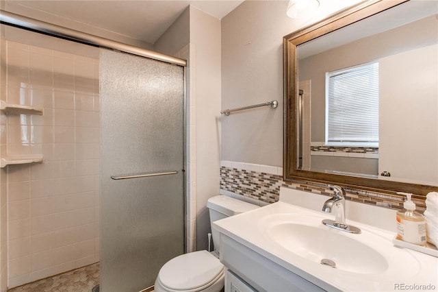 bathroom featuring tile walls, vanity, a shower with shower door, and toilet