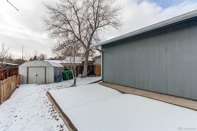 view of snowy exterior featuring a storage unit