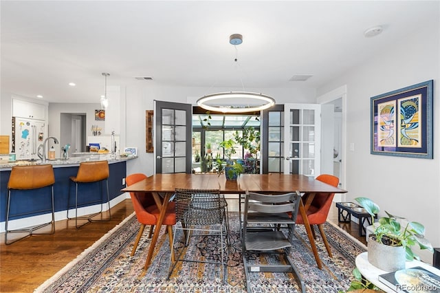 dining area featuring dark hardwood / wood-style flooring, sink, and french doors