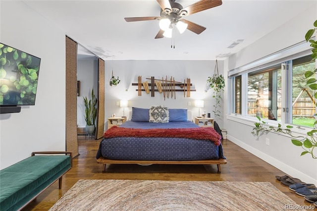 bedroom with dark hardwood / wood-style flooring and ceiling fan