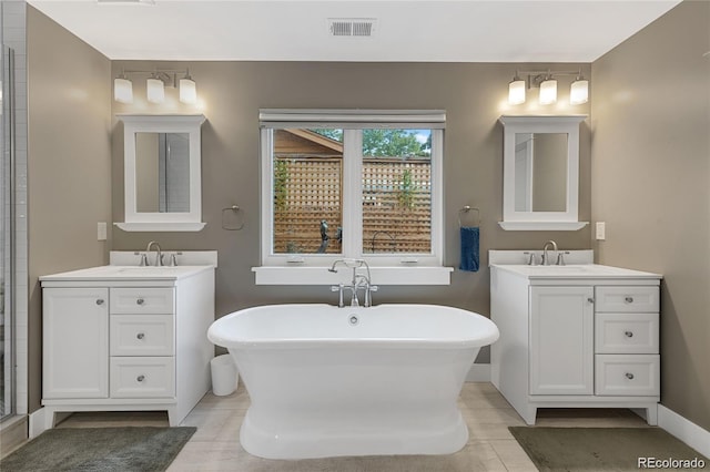 bathroom with tile patterned flooring, vanity, and a bathtub