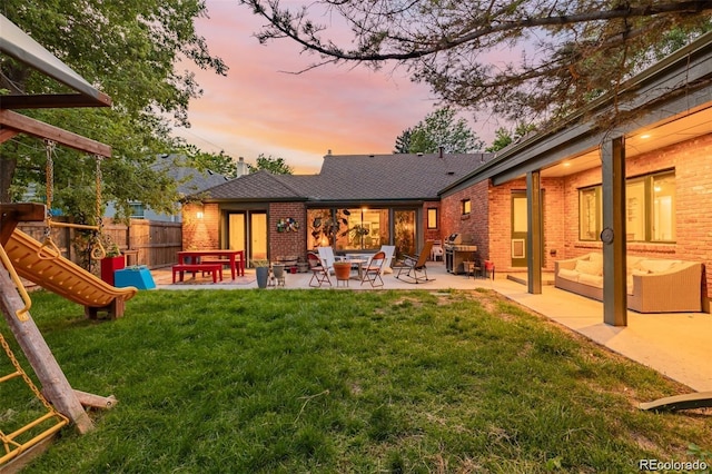 yard at dusk with a patio and a playground