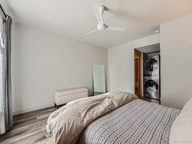 bedroom with ceiling fan, wood-type flooring, and stacked washer and clothes dryer