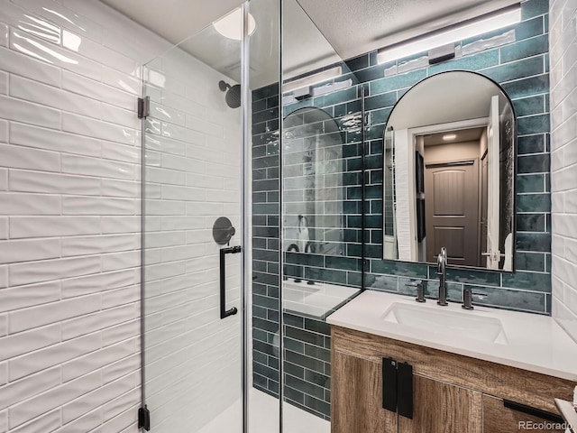 bathroom with vanity, an enclosed shower, and tile walls