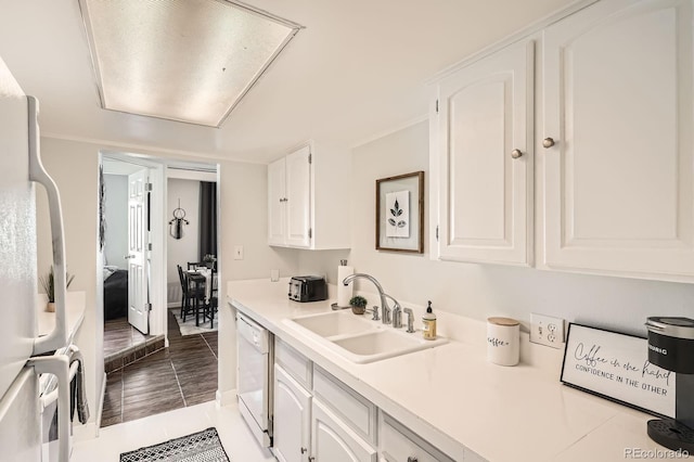 kitchen with white appliances, white cabinets, tile patterned floors, light countertops, and a sink