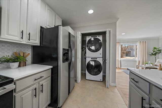 washroom with light tile patterned floors, laundry area, recessed lighting, crown molding, and stacked washer / dryer