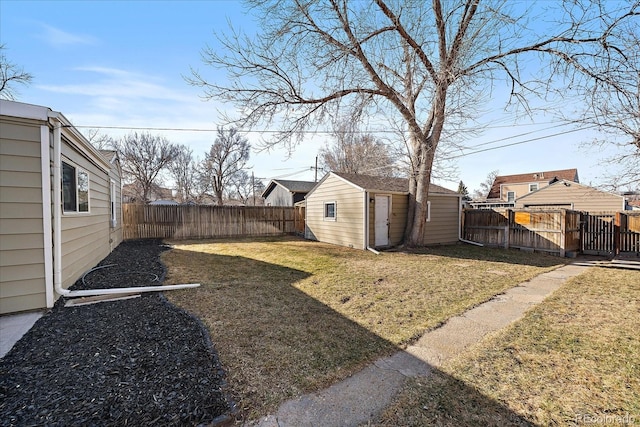 view of yard featuring an outdoor structure, a gate, and a fenced backyard