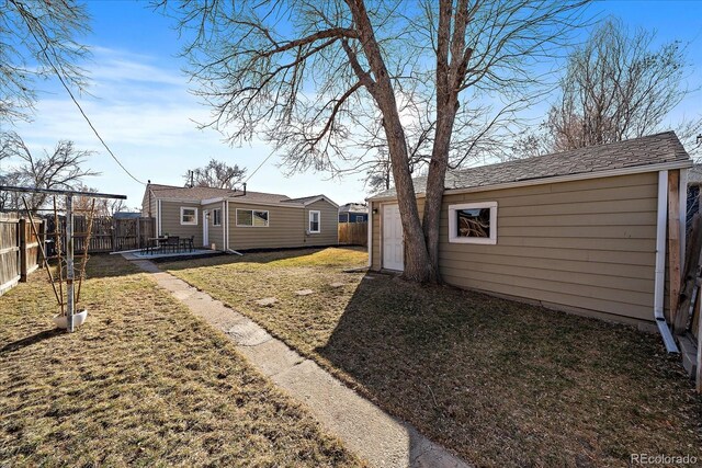 view of yard with an outbuilding, a patio area, and a fenced backyard