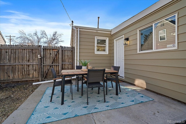 view of patio / terrace with a gate, outdoor dining space, and fence