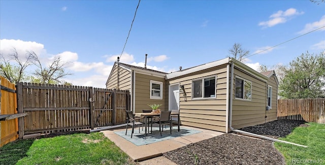 rear view of house with a fenced backyard and a patio area