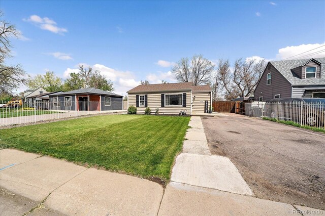 view of front of house with aphalt driveway, fence, and a front yard