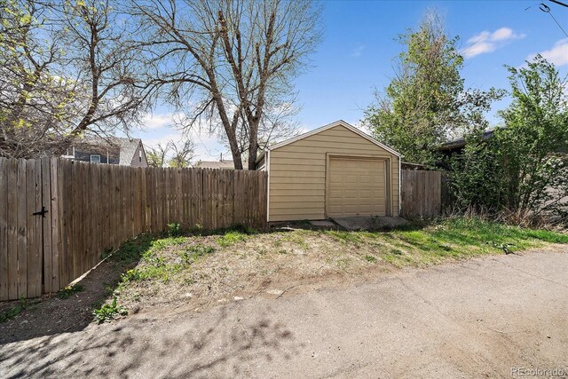 detached garage with fence and driveway
