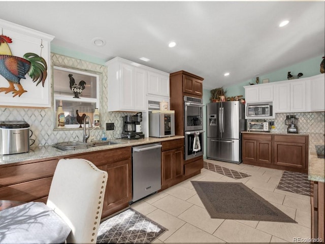 317 Adams Ave, Akron, CO 80720 - kitchen with vaulted ceiling, sink, decorative backsplash, light tile patterned floors, and stainless steel appliances