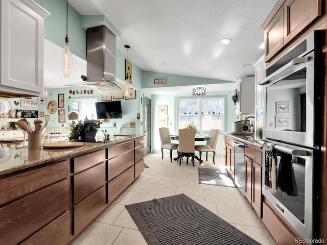 317 Adams Ave, Akron, CO 80720 - kitchen featuring white cabinetry, vaulted ceiling, hanging light fixtures, light tile patterned floors, and appliances with stainless steel finishes