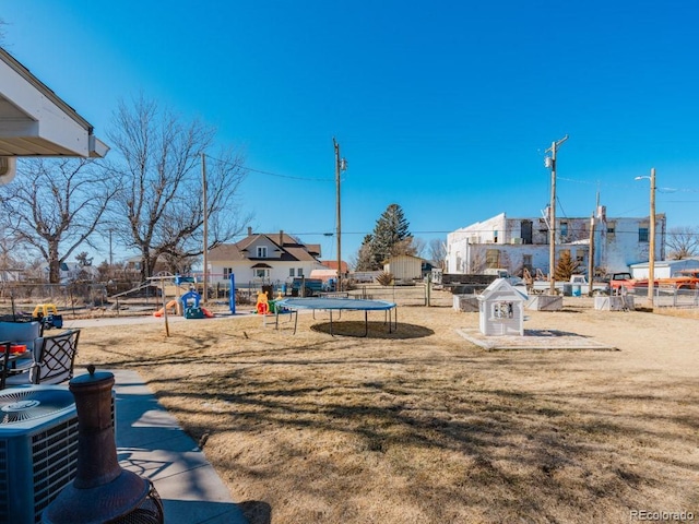 317 Adams Ave, Akron, CO 80720 - view of jungle gym featuring a trampoline, cooling unit, and a lawn