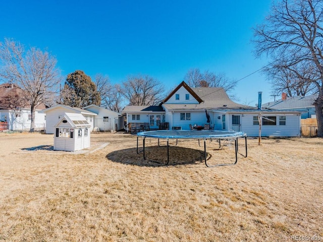 317 Adams Ave, Akron, CO 80720 - back of house featuring a lawn, a trampoline, and a storage unit